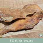 Morceaux de filet de poulet séché présentés sur une table.