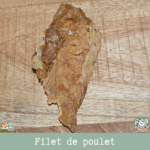 Morceaux de filet de poulet séché présentés sur une table.