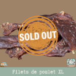 Morceaux de filet de poulet séché présentés sur une table.