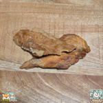 Morceaux de filet de poulet séché présentés sur une table.