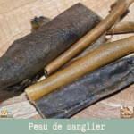 Morceaux de peau de sanglier séchée présentés sur une table.