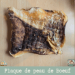 Plaque de peau de bœuf séchée présentée sur une table.