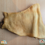 Plaque de peau de bœuf séchée présentée sur une table.