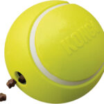 La balle de tennis Kong® Rewards Tennis Jaune, montrant l'ouverture pour insérer des friandises.